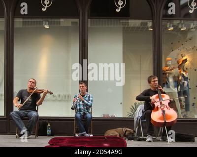 ARCOS DE LA FRONTERA, SPAGNA - 12 aprile 2015: Arcos de la Frontera, Cadice / Spagna - 11 2015 aprile: Musicisti con un cane che suona Clarinet, violino e Cel Foto Stock