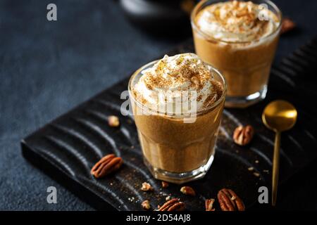 Frullato di zucca autunnale con panna montata e cannella. Serviti in bicchieri. Foto Stock