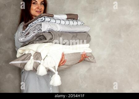 Bella donna in inverno spessa calda accappatoio è seduta e. lenzuola e asciugamani da bagno ben pieghevoli Foto Stock