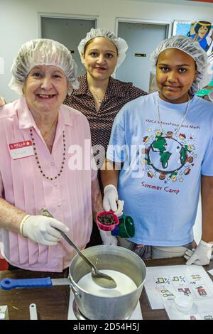 Miami Florida,giorno intergenerazionale delle guarnizioni di Pasqua,volontari della cucina preparano i pasti del cibo del pranzo,donna africana nera ispanica w Foto Stock