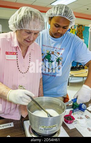 Miami Florida,giorno intergenerazionale delle guarnizioni di Pasqua,volontari della cucina preparano i pasti del cibo del pranzo,donna africana nera ispanica w Foto Stock