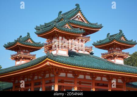 La vista dei tetti curvi coperti da tegole blu-verdi in stile heki-gawara sulle colonne vermiglio luminose della Torre Byakko-ro al Santuario di Heian-jingu. K Foto Stock