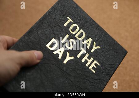 Copybook nero con 'oggi è il giorno' scritto su di esso Foto Stock