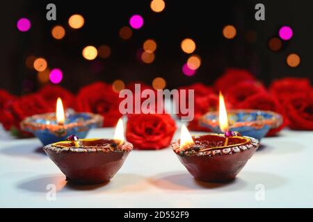 Decorazione Diwali con colorate lampade ad olio e fiori sfondo Foto Stock