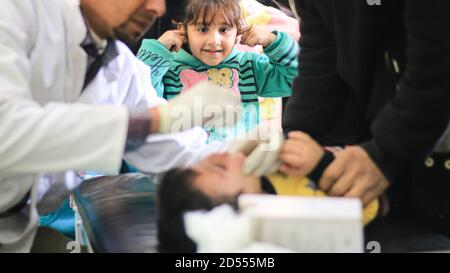 nurse cerca di far ridere un bambino malato Foto Stock