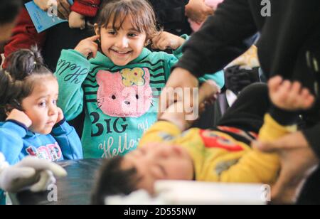 nurse cerca di far ridere un bambino malato Foto Stock