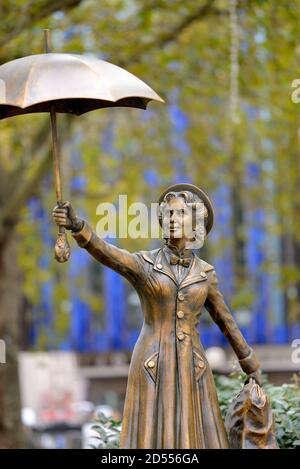 Londra, Inghilterra, Regno Unito. Statua di bronzo di Mary Poppins in Leicester Square, scene nel percorso della piazza Foto Stock