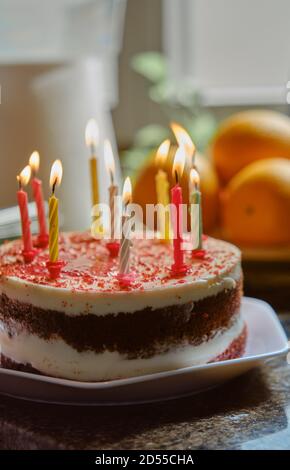 torta di compleanno con candele sottili brucianti Foto Stock