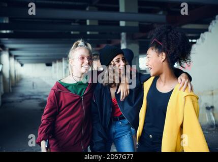 Gruppo di ragazzine adolescenti in piedi al coperto in un edificio abbandonato, appendere fuori. Foto Stock