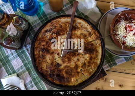 Torta tradizionale serba - pita rossa a strati ripiena di formaggio e cotto in un sacco speciale pentola Foto Stock