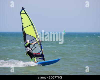 Windsurf sulla spiaggia di Pagham, West Sussex. Foto Stock