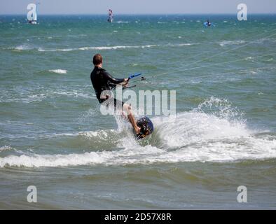 Kitesurf vicino alla spiaggia di Pagham, West Sussex. Foto Stock