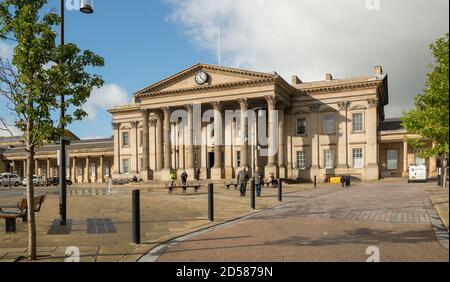 St George's Square e l'imponente facciata della stazione ferroviaria vittoriana di Huddersfield, West Yorkshire Foto Stock