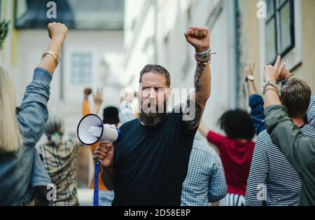 Ritratto dell'uomo con il megafono che protesta per le strade, lo sciopero e il concetto di dimostrazione. Foto Stock