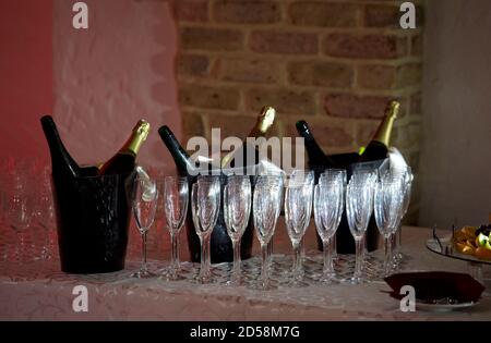 Primo piano di flute di champagne e bottiglie di champagne nei refrigeratori Foto Stock