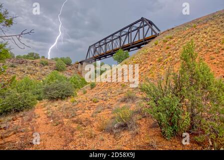 Fulmini da una tempesta monsonica che colpisce vicino a un vecchio ponte ferroviario a traliccio che attraversa Bear Canyon vicino a Perkinsville, Arizona. Foto Stock