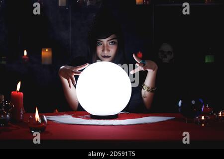 Fortune teller nel cofano nero prevedere il futuro evento o destino utilizzando la palla di cristallo. Foto Stock