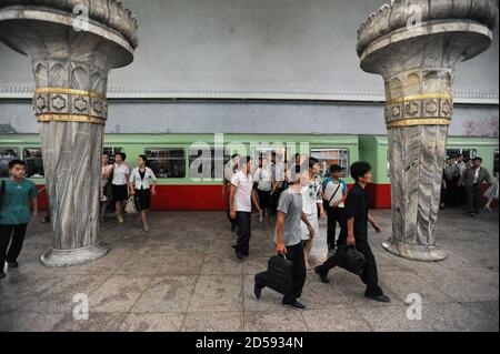 09.08.2012, Pyongyang, Corea del Nord, Asia - pendolari su una piattaforma della stazione della metropolitana con il treno della metropolitana di Pyongyang in attesa. Foto Stock