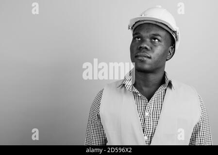 Giovane africano lavoratore edile contro uno sfondo bianco Foto Stock