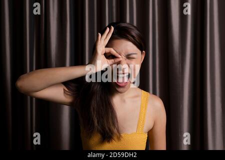 Ritratto di una donna che guarda attraverso le dita Foto Stock