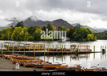 Barche a remi su Derwentwater con le tavole di atterraggio con Cat Bells Beyond Derwent Isle nel Lake District National Park in autunno. Keswick Cumbria Inghilterra Regno Unito Foto Stock