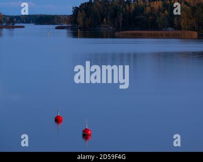 Helsinki/Finlandia - 11 OTTOBRE 2020: Due boe rosse galleggiano in mare calmo in una bella serata autunnale. Foto Stock