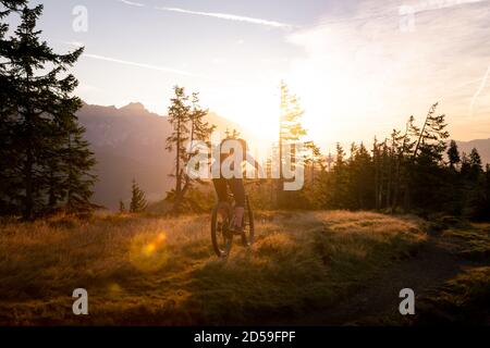 Donna mountain bike in montagna all'alba, Fadstadt, Salisburgo, Austria Foto Stock