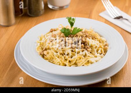 Tagliatella Turca / Eriste con formaggio, noci su fondo di legno Foto Stock