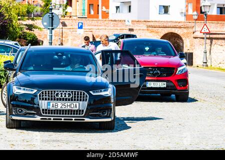 Auto moderne parcheggiate su una strada. Audi A6 nera e Mercedes Benz GLC rossa in classe Alba Iulia, 2020 Foto Stock