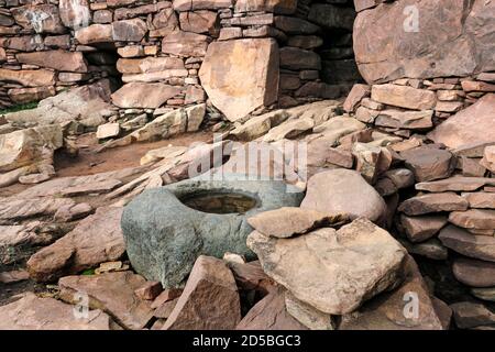 La pietra di Koking nell'interno del Broch di Clachtold (un Dun) che è sotto minaccia da erosione costiera e danni di tempesta, Costa occidentale di Assynt, NW Highl Foto Stock