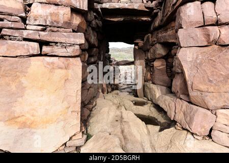 L'ingresso ai resti di Clachtold Broch (un Dun) che è sotto minaccia di erosione costiera e danni tempesta, West Coast di Assynt, NW Highland Foto Stock