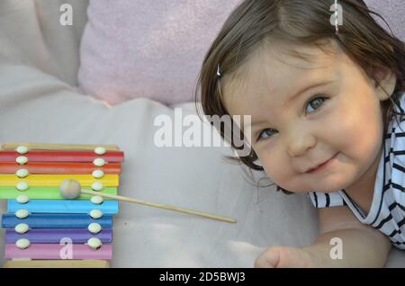 Carino bambino biondo giocare con xilofono a casa. Concetto di creatività e istruzione. Foto Stock