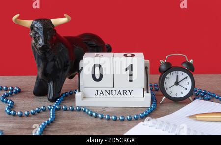statua del toro e il calendario. Gennaio 01, pianificazione per la giornata. Obiettivi a lungo termine per l'anno. Fuoco selettivo. Foto Stock