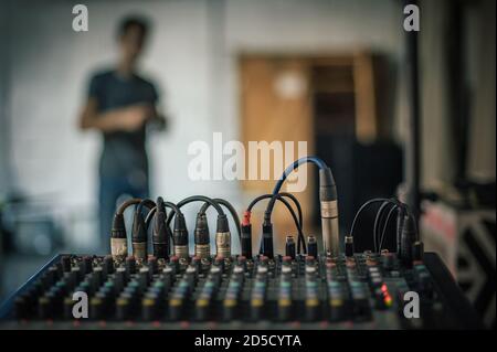 Dietro la scena. Tecnico del suono, ingegnere elettrico che regola il backstage degli elementi sonori. Quadro comandi audio. Console di mixaggio audio Foto Stock