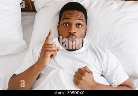 L'uomo afro-americano che ha l'idea di mentire nel letto a casa Foto Stock