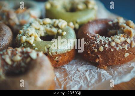 Ciambelle per lunch.Donuts preparato in panetteria cafe per colazione meal.Pasticy Prodotti con glassa al pistacchio e noci. Delizioso dessert al forno io Foto Stock