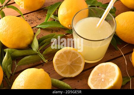 Spremuta fresca su un tavolo di legno su un vassoio pieno di limoni. Vista rialzata. Composizione orizzontale. Foto Stock