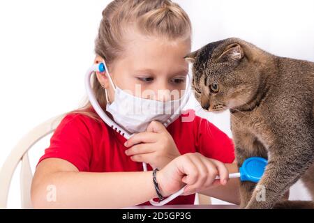 Bambina che gioca al veterinario - consultando il suo piccolo gattino Foto Stock