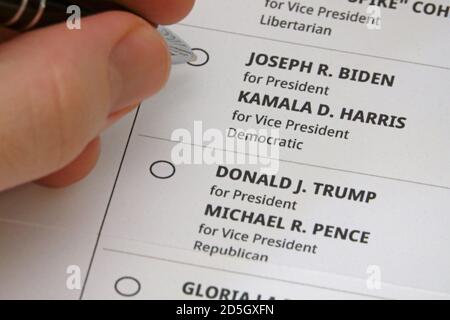 Los Angeles, CA / USA - 12 ottobre 2020: Una mano che tiene una penna è indicato circa per riempire una bolla per votare per Joseph ( Joe ) R. Biden come presidente. Foto Stock