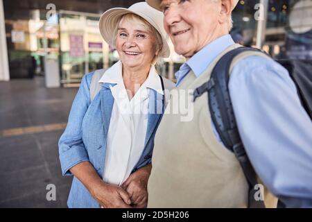 Felice viaggiatore che tiene il marito per mano Foto Stock