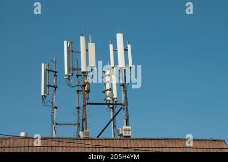 Il cellulare antenna di comunicazione sulla copertura di un edificio Foto Stock