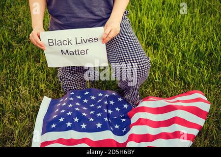 Donna che rinuncia 'Black Lives Matter' segni durante un raduno per parlare della pluralità di violenza e anti-razzismo nero. Black Lives Matter slogan su UN Foto Stock