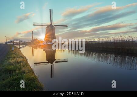 Il mulino a vento De Kaagmolen di fronte a un canale e barca, Olanda del Nord, Paesi Bassi Foto Stock