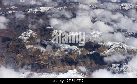 Il corso superiore del fiume Indus, vista aerea, cime innevate tra le nuvole, Himalaya, India del Nord Foto Stock