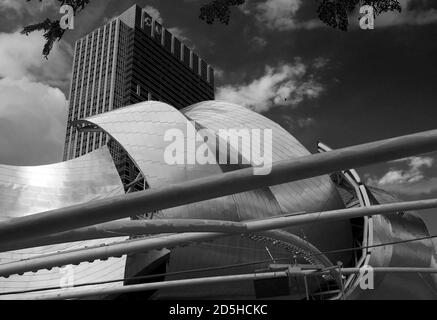 Jay Pritzker Pavilion, Millennium Park, Chicago con un edificio alto sullo sfondo Foto Stock