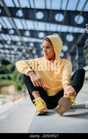 Donna attiva in abbigliamento sportivo riposante durante la giornata di sole Foto Stock