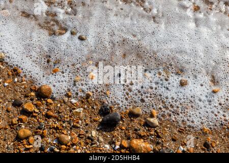 Onde che lambiscono i ciottoli sulla spiaggia di Brighton, Inghilterra, Regno Unito Foto Stock