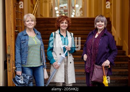 Tre donne anziane si trovano all'ingresso del centro commerciale della città. Foto Stock