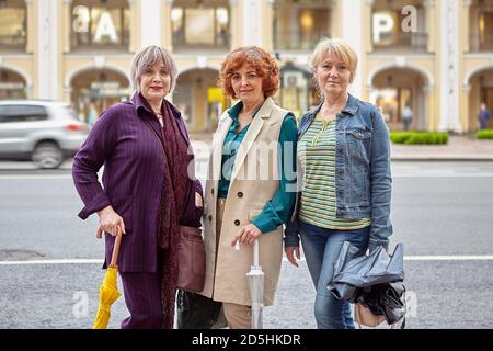 Tre donne europee mature sono fotografate di fronte a un centro commerciale. Foto Stock