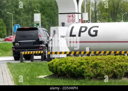 Stazione di gas propano liquido. Serbatoio di rifornimento SUV moderno nero con carburante liquefatto naturale a potenza alternativa Foto Stock